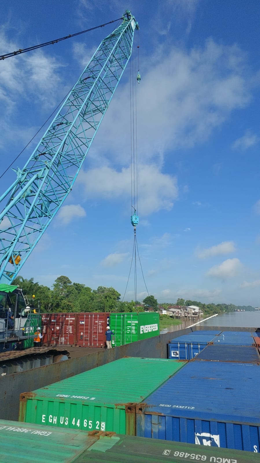 Crane mengangkat kontainer di area pelabuhan